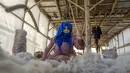 Seorang wanita Afghanistan membersihkan wol untuk membuat karpet di pabrik karpet tradisional di Kabul, Afghanistan, Minggu (5/3/2023). Setelah Taliban berkuasa di Afghanistan, banyak hak dasar wanita telah dirampas. (AP Photo/Ebrahim Noroozi)