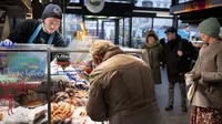 Pelanggan di pasar ikan di Torvehallerne di Kopenhagen, Denmark, Selasa (1/2/2022). Otoritas Kesehatan Denmark saat ini "merekomendasikan" mereka yang dites positif untuk diisolasi selama empat hari, sementara kasus kontak tidak perlu lagi dikarantina. (Liselotte Sabroe/Ritzau Scanpix via AP)