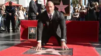 Dwayne Johnson berpose di sebuah plakat bintang atas namanya dari Hollywood Walk of Fame di Los Angeles, Jumat (13/12). The Rock mengungkapkan rasa bahagianya atas pemberian bintang ini lewat akun media sosialnya. (Photo by Willy Sanjuan/Invision/AP)