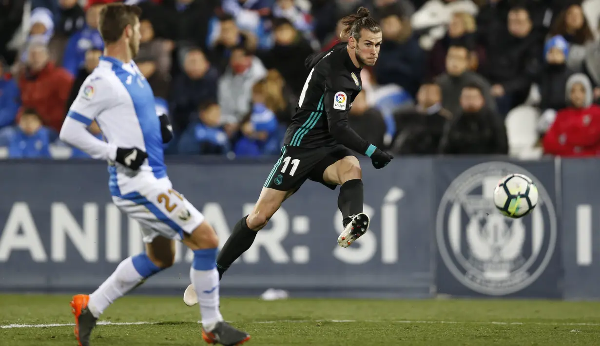 Pemain Real Madrid, Gareth Bale (kanan) melepaskan tembakan melewati adangan pemain Leganes, Ruben Perez pada lanjutan La Liga Santander di Butarque stadium, Leganes, (21/2/2018). Real Madrid menang 3-1.  (AP/Francisco Seco)