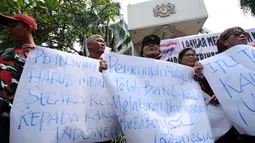 Peserta aksi membentangkan kertas pesan saat berunjuk rasa di depan Kedubes Malaysia, Jakarta, Senin (21/8). Aksi ini terkait kasus terbaliknya bendera Merah Putih pada buku panduan pelaksanaan SEA Games 2017. (Liputan6.com/Helmi Fithriansyah)