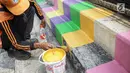 Pasukan oranye atau PPSU menyelesaikan pengecatan warna-warni jembatan layang di kampung Makasar, Jakarta, Kamis (26/7).  Pengecatan dilakukan guna mempercantik dan menyambut Asian Games 2018 pada bulan Agustus mendatang.  (Liputan6.com/Faizal Fanani)