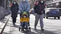 Wanita yang mengenakan masker berjalan dengan anak-anak mereka di jalan menuju Kota Terlarang di Beijing, Selasa (17/1/2023). Penurunan  populasi tersebut lebih dari tiga kali lipat prediksi penurunan sebelumnya pada 2019.
(AP Photo/Andy Wong)