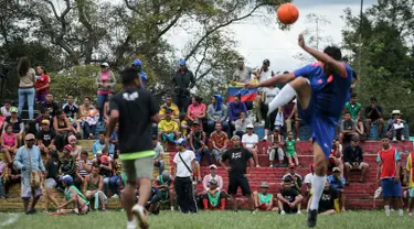 Para migran Venezuela bermain sepak bola di kamp sementara di Bogota, Kolombia (21/11). Pejabat kota menyelenggarakan turnamen sepak bola bagi migran yang tinggal di kamp yang dibangun badan kesejahteraan sosial kota tersebut. (AP Photo/Ivan Valencia)