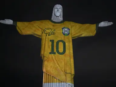 Sebuah gambar yang diproyeksikan ke patung Kristus Sang Penebus memberi penghormatan kepada legenda sepak bola Brasil Pele pada peringatan satu tahun kematiannya, di Gunung Corcovado di Rio de Janeiro, Brasil, Jumat (29/12/2023). (Mauro PIMENTEL / AFP)