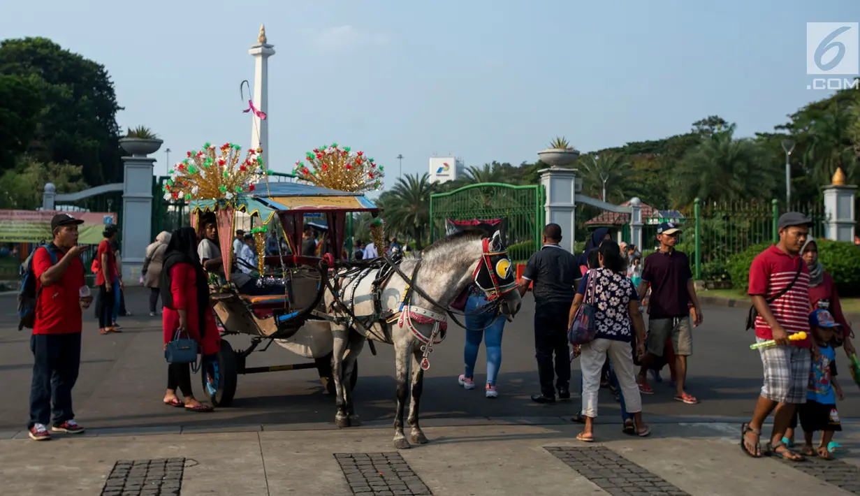 Pengunjung naik delman melintas di depan Monas ketika hari libur Lebaran hari kedua, Jakarta, Kamis (6/6/2019). Libur hari Lebaran dimanfaatkan sejumlah warga dari Jabodetabek untuk berpergian ke tempat wisata yang ada di Jakarta. (merdeka.com/Imam Buhori)