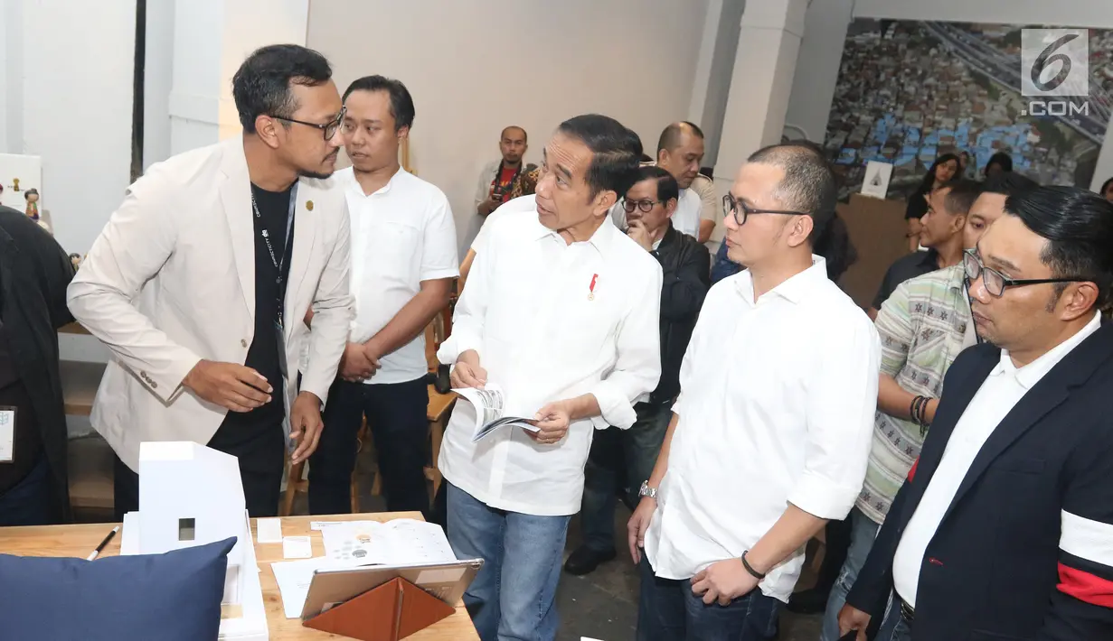 Calon Presiden Nomor Urut 01 Joko Widodo atau Jokowi menyimak penjelasan maket rumah sebelum berdiskusi dengan masyarakat kreatif Bandung di Simpul Space, Bandung, Jawa Barat,  Sabtu (10/11). (Liputan6.com/Angga Yuniar)