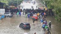 Wilayah terdampak tersebar di Jakarta Selatan dan Jakarta Utara. Di Jakarta Selatan, banjir merendam delapan RT, sementara dua RT lainnya berada di Jakarta Utara. Tampak dalam foto, pengendara dan pejalan kaki melintasi banjir yang menggenangi Jalan Jembatan Tiga Raya, Jakarta Utara, Senin (12/1/2026). (merdeka.com/Arie Basuki)