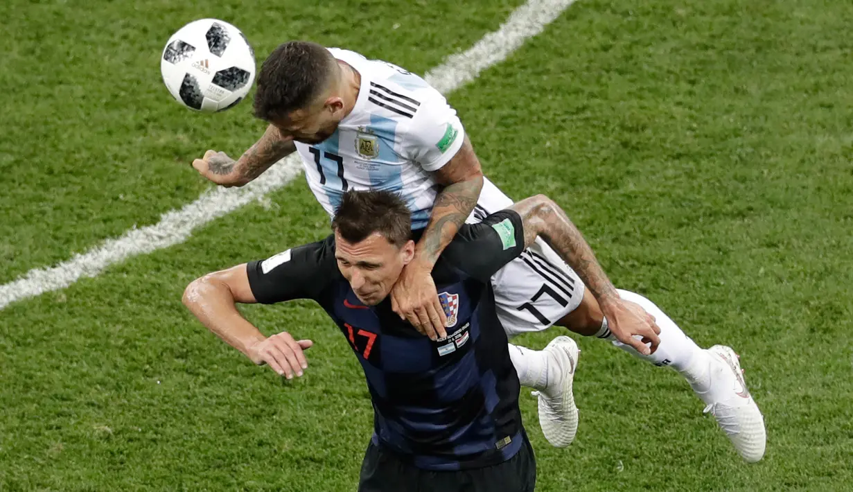 Pemain Argentina, Nicolas Otamendi berebut bola dengan pemain Kroasia, Mario Mandzukic pada pertandingan Grup D Piala Dunia 2018 di Nizhy Novgorod Stadium, Rusia, Jumat (22/6). Menghadapi Kroasia, Argentina takluk dengan skor 0-3. (AP/Michael Sohn)
