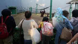 Pengunjung menyaksikan orangutan saat mengisi libur Lebaran di Kebun Binatang Ragunan, Jakarta, Sabtu (16/6). Kebun Binatang Ragunan masih menjadi tempat favorit warga Jakarta untuk menghabiskan libur Lebaran. (Liputan6.com/JohanTallo)
