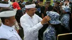 Gubernur Jawa Barat Dedi Mulyadi merapikan topi yang dikenakan salah satu siswa peserta program Pembinaan Karakter dan Bela Negara di lapangan Markas Divisi Infanteri 1 Kostrad, Cilodong, Kota Depok, Senin (9/6/2025). (Liputan6.com/Herman Zakharia)