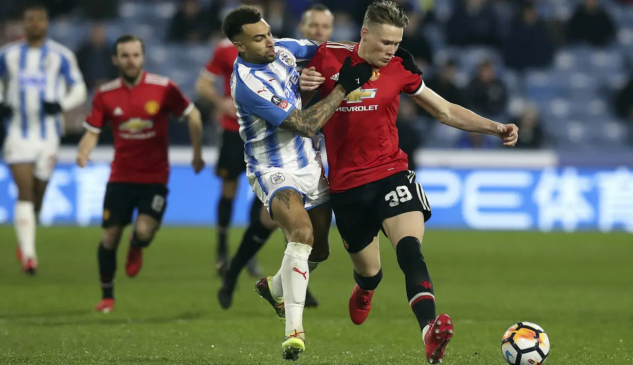 Aksi pemain Huddersfield, Danny Williams (kiri) menahan laju pemain Manchester United, Scott McTominay pada putaran kelima Piala FA di John Smith stadium, Huddersfield, (17/2/2018). Manchester United menang 2-0. (Martin Rickett/PA via AP)