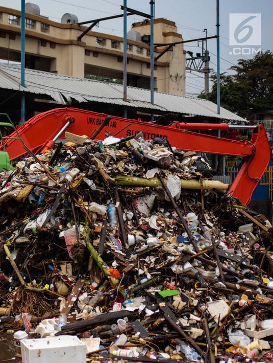 Alat berat beroperasi mengangkut sampah yang menumpuk di Pintu Air Manggarai, Jakarta, Selasa (4/12). Tingginya intensitas hujan di wilayah Jabodetabek membuat sampah yang terbawa arus sungai menumpuk di Pintu Air Manggarai. (Liputan6.com/Faizal Fanani)
