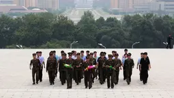 Tentara membawa bunga saat akan memberi penghormatan kepada patung pemimpin Korea Utara Kim Il Sung dan Kim Jong Il dalam peringatan berakhirnya Perang Dunia II dan pembebasan dari kolonial Jepang di Pyongyang, Korut, Rabu (15/8). (AP Photo/Ng Han Guan)