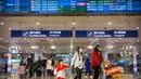 <p>Penerbangan dari Wuhan Ditutup: Pelancong berjalan melintasi papan informasi tentang penerbangan dari Wuhan telah dibatalkan di Bandara Internasional Ibu Kota Beijing pada Kamis (23/1/2020). China menangguhkan semua transportasi dari dan ke kota pusat penyebaran virus corona. (AP/Mark Schiefelbein)</p>