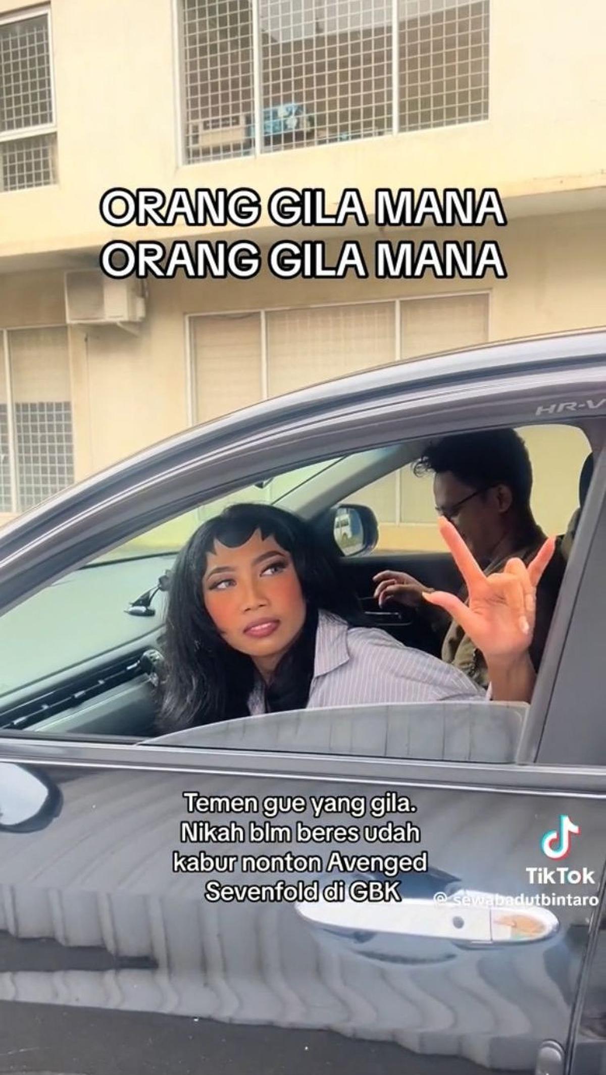 Sebelum pergi, pengantin yang masih memakai paes ini bahkan membuat sign metal dengan tangannya.