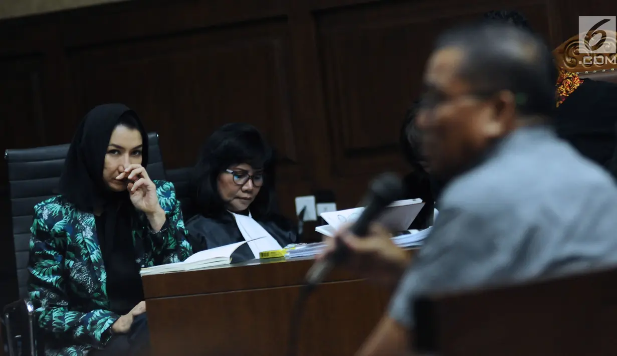 Bupati nonaktif Kutai Kartanegara, Rita Widyasari (kiri) menyimak keterangan saksi pada sidang lanjutan dugaan suap pemberian izin lokasi perkebunan kelapa sawit di Pengadilan Tipikor, Jakarta, Rabu (14/3). (Liputan6.com/Helmi Fithriansyah)