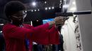 Seorang wanita memegang pistol dengan peredam di Pameran Internasional Pertahanan dan Keamanan LAAD di Rio de Janeiro, Brasil, Selasa, 11 April 2023. (AP Photo/Bruna Prado)