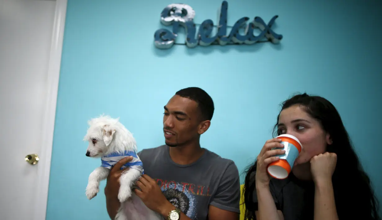 Pengunjung bermain bersama anak anjing saat mengunjungi Dog Cafe di Los Angeles, AS (7/4). Di kafe ini pengunjung dapat bermain dan mengadopsi anjing yang berada di kafe ini. (REUTERS/Lucy Nicholson)