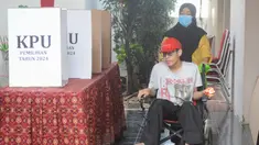 Penyandang disabilitas bersama pendamping menggunakan hak pilihnya pada Pemilihan Kepala Daerah (Pilkada) Serentak 2004 di Tempat Pemungutan Suara (TPS) 31 kawasan Lebak Bulus, Jakarta Selatan, Rabu (27/11/2024). (merdeka.com/Arie Basuki)