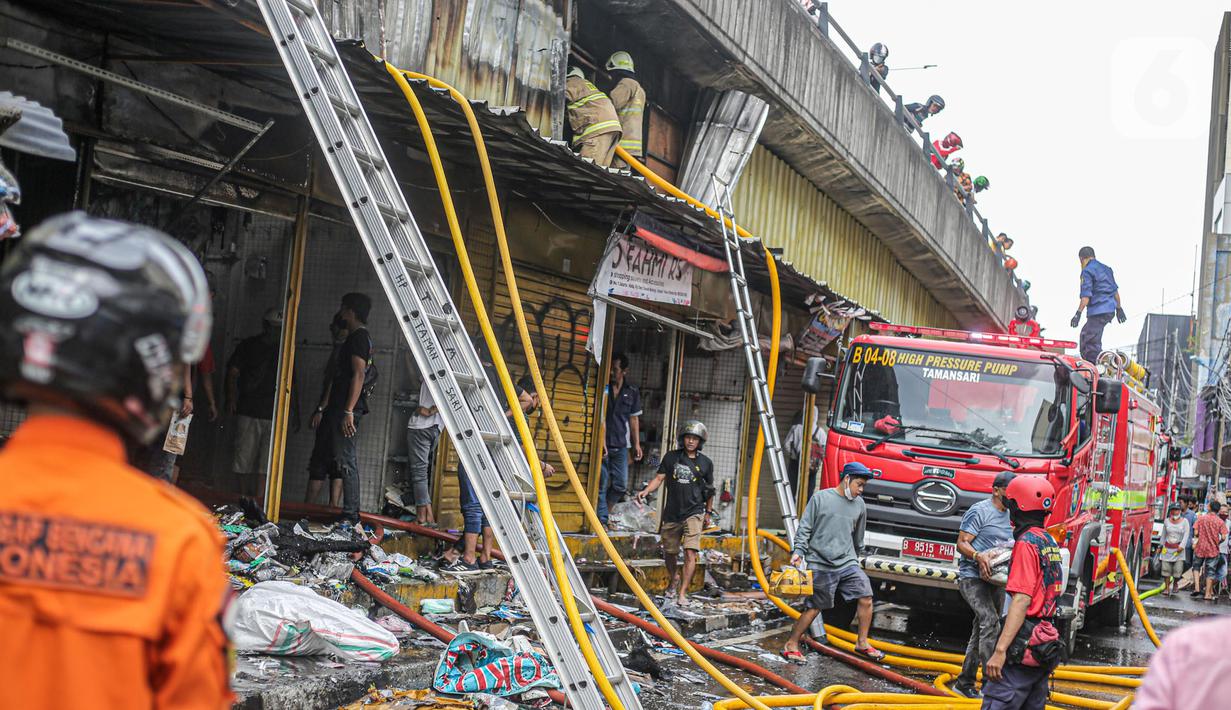 Pedagang menyelamatkan barang dagangan saat proses pendinginan oleh damkar dari kebakaran di Pasar Pagi Asemka, Jakarta, Jumat (18/11/2022). Kebakaran terjadi sekitar pukul 11.30 WIB. Sebanyak Sebanyak 14 unit kendaraan pemadam beserta 70 personel dikerahkan untuk menanggulangi kebakaran. (Liputan6.com/Faizal Fanani)
