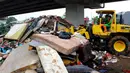 Petugas PPSU DKI Jakarta menggunakan alat berat saat membersihkan sampah sisa banjir di bawah Tol Becakayu, Cipinang Melayu, Jakarta Timur, Rabu (8/1/2020). Sampah sisa banjir tersebut selanjutnya diangkut ke TPA Bantar Gebang. (merdeka.com/Magang/Muhammad Fayyadh)