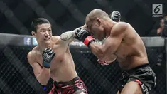 Petarung China, Peng Xue Wen (kiri) melakukan pukulan ke petarung Filipina, Rene Catalan (kanan) saat berlaga pada One Championship di Jakarta, Sabtu (20/1). Petarung Rene Catalan menang atas Peng Xue Wen. (Liputan6.com/Faizal Fanani)