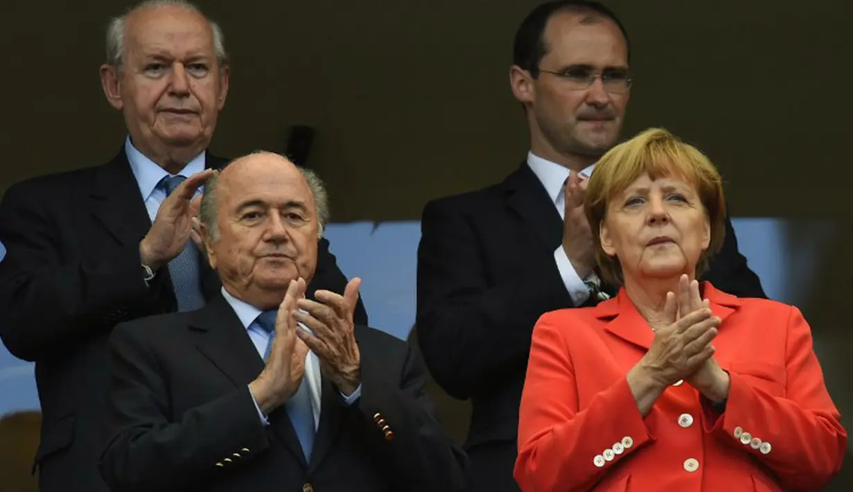 Bersama Persiden FIFA, Sepp Blatter (kiri - bawah), Kanselir Jerman, Angela Merkel memberikan applaus kepada para pemain yang berlaga di babak penyisihan Piala Dunia Grup G di Fonte Nova Arena, Brasil, (16/6/2014). (AFP PHOTO/Fabrice Coffrini)