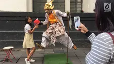 Pengunjung berpose dengan manusia patung di kawasan Museum Fatahilah, Kota Tua, Jakarta, Jumat (16/2). Libur Imlek 2018 dimanfaatkan warga untuk berwisata di sejumlah lokasi, Salah satu yang ramai dikunjungi yakni Kota Tua (Liputan6.com/Immanuel Antonius)