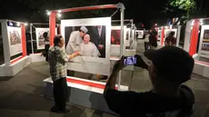 Pengunjung memperhatikan foto yang dipamerkan pameran foto para pemenang Anugerah Pewarta Foto Indonesia (APFI) 2025 di Loji Gandrung, Solo, Jawa Tengah, Jumat (25/4/2025). (merdeka.com/Arie Basuki)