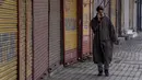 Pria Kashmir berjalan di luar pasar tertutup di Srinagar, Kashmir yang dikuasai India, Sabtu (15/1/2022). Pihak berwenang di bagian Kashmir India mengumumkan pembatasan penuh pergerakan yang tidak penting selama akhir pekan di seluruh negara bagian untuk mengekang COVID-19. (AP Photo/Dar Yasin)