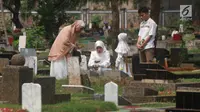 Warga berdoa saat berziarah di TPU Karet Pasar Baru Barat, Jakarta, Sabtu (16/6). Ziarah kubur atau "nyekar" pada hari raya lebaran merupakan salah satu tradisi umat muslim untuk mendoakan sanak keluarga yang meninggal dunia. (Liputan6.com/Arya Manggala)