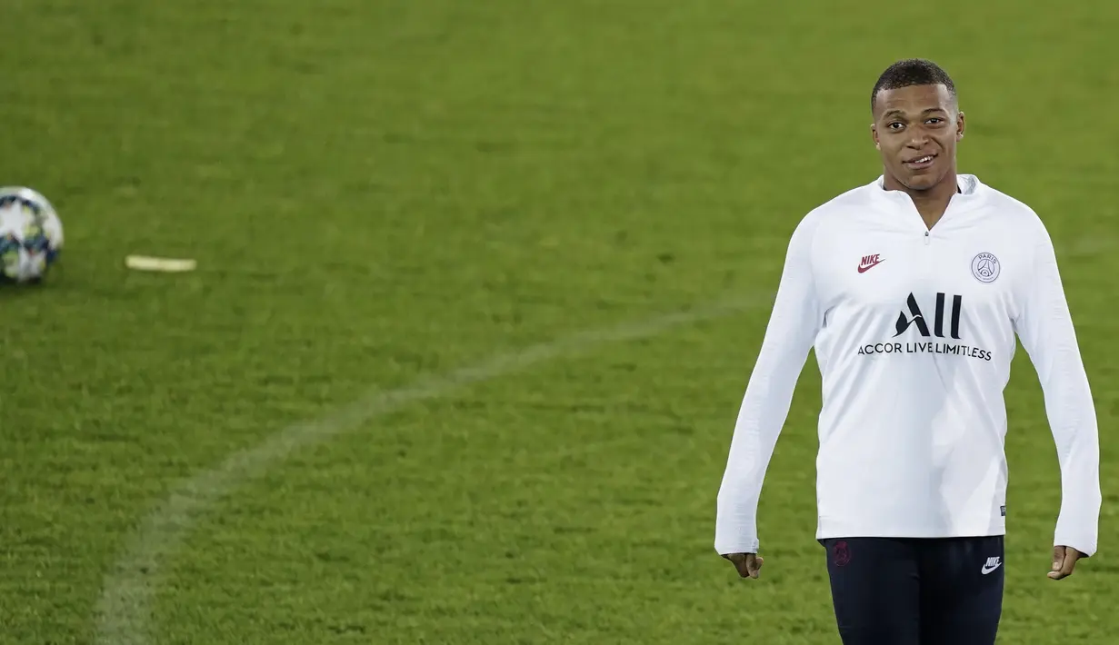 Penyerang Paris Saint-Germain (PSG), Kylian Mbappe tersenyum saat mengikuti sesi latihan tim di Jan Breydel Stadium di Bruges (21/10/2019). PSG akan bertanding pada matchday ketiga Grup A Liga Champions melawan wakil Belgia, Club Brugge. (AFP Photo/Kenzo Tribouillard)