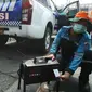 Petugas melakukan uji emisi pada kendaraan dinas operasional di Subdit Gakkum Ditlantas Polda Metro Jaya, Jakarta, Jumat (1/9/2023). (Liputan6.com/Herman Zakharia)