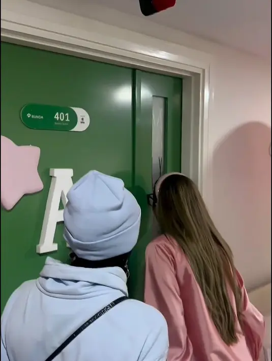 Sebelum bisa masuk, nenek baby A tampak saling bergantian mengintip dari kaca di pintu. Momen istri Anang saat penasaran ingin melihat adik Ameena. [Instagram/ashanty_ash]