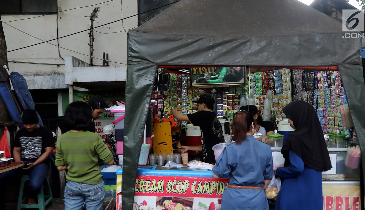 Pedagang melayani pembeli di Pasar Takjil Kebon Kacang, Jakarta, Senin (29/5). Meski berada di gang sempit, pasar tersebut menjadi lokasi favorit warga yang akan membeli makanan untuk hidangan berbuka puasa. (Liputan6.com/Johan Tallo)