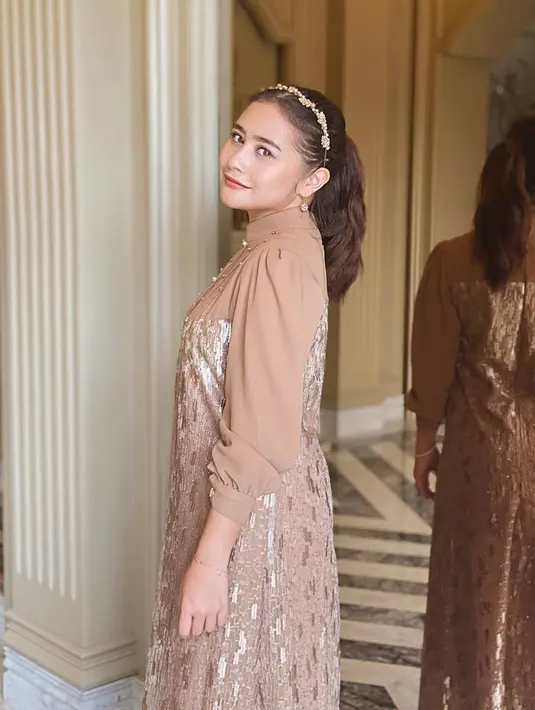 Tata rambut dengan gaya rambut kuncir kuda disertai dengan bandana cantik, penampilan Prilly Latuconsina ini semakin memesona. Tak dipungkiri, gaya rambut kuncir kuda tersebut cocok dengan outfit yang simpel nan anggun dikenakan Prilly Latuconsina. Perpaduan warna dress dan bandana Prilly juga membuat penampilannya tampak selaras. (Liputan6/IG/@prillylatuconsina96)