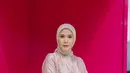 Cynthia Ramlan tampil kasual dengan kemeja satin beige dengan jeans. Ia pun mengenakan hijab dan menjinjing tas dengan warna senada [Barbie x Ayu Lestari]