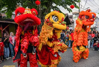 Para penari barongsai tampil di hadapan warga pada hari perayaan Tahun Baru Imlek di Kawasan Pecinan Surabaya, Jawa Timur pada Rabu 29 Januari 2025. (JUNI KRISWANTO/AFP)