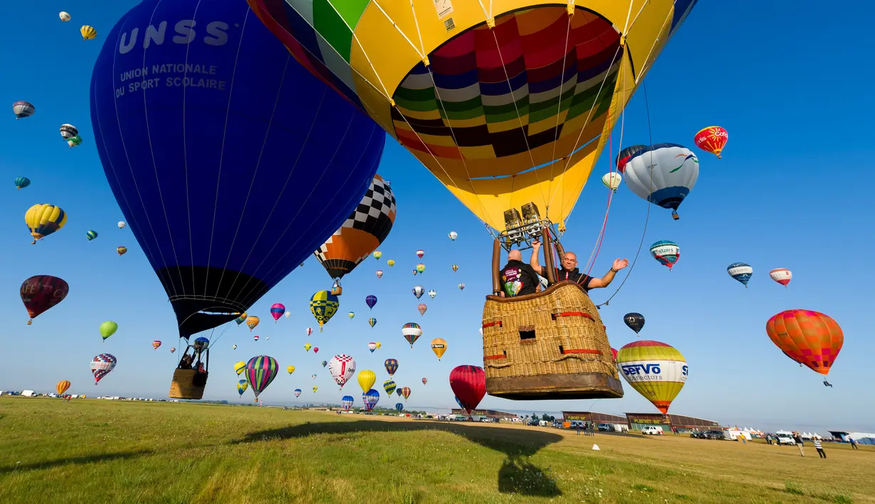 Ratusan balon udara terbang di pangkalan udara Chambley-Bussieres, Hagéville, Prancis, Senin (29/7/2019). Acara ini bagian dari pertemuan Grand-Est Mondial Air Ballons (GEMAB). (Jean-Christophe VERHAEGEN/AFP)