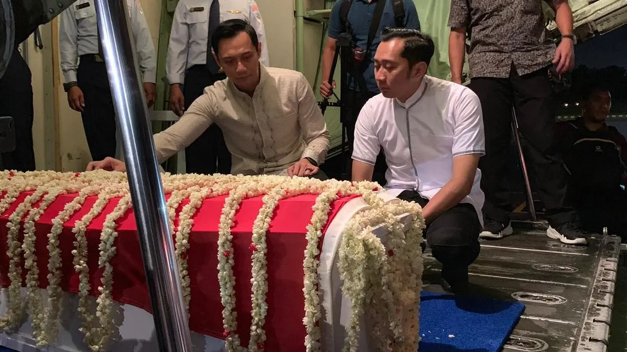 Dua putra Ani Yudhoyono, Agus Harimurti Yudhoyono dan Edhie Baskoro Yudhoyono, memegang peti jenazah dan mendampinginya saat masuk ke pesawat.
