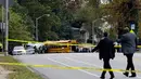 Pejabat setempat meninjau lokasi kecelakaan antara bus komuter dengan bus sekolah di Baltimore, Maryland, Selasa (1/11). Hingga saat ini, otoritas berwenang di Baltimore belum memberikan informasi terkait penyebab kecelakaan. (AP Photo/Patrick Semansky)