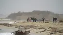 Puing-puing kapal terbalik terdampar di pantai dekat Cutro, Italia selatan, Minggu, 26 Februari 2023. Setidaknya 59 imigran, termasuk 11 anak-anak dan seorang bayi yang baru lahir, meninggal dan puluhan lainnya diselamatkan setelah kapal mereka yang kelebihan muatan tenggelam. (Antonino Durso/LaPresse via AP)