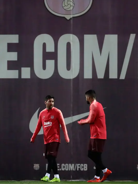 Penyerang Barcelona, Lionel Messi dan Luis Suarez berbincang selama sesi latihan di Sports Center FC Barcelona Joan Gamper di Sant Joan Despi, Spanyol (12/3). Pada leg pertama Barcelona bermain imbang 0-0 di Markas Lyon. (AP Photo/Manu Fernandez)