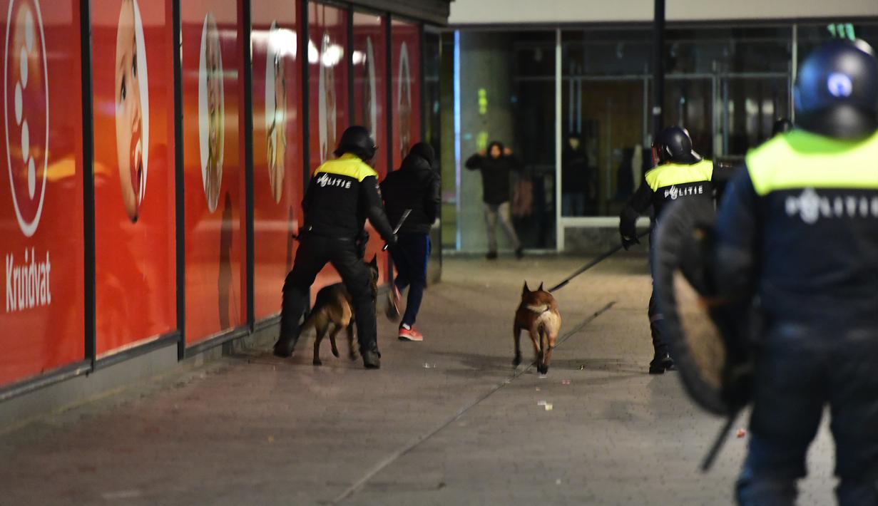 Polisi mengerahkan anjing pelacak untuk membubarkan aksi protes yang digelar oleh warga Turki di Rotterdam, Belanda (11/3). Aksi protes dilancarkan setelah Pemerintah Belanda melarang Menteri Luar Negeri Turki mendarat di Belanda. (AFP/Emmanuel Dunand)