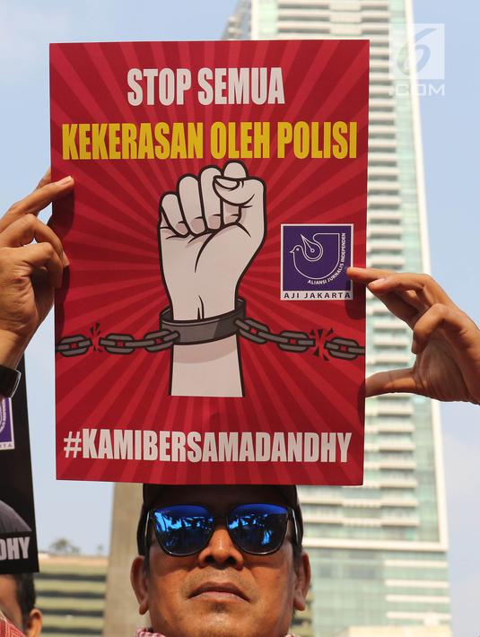 Jurnalis yang tergabung dalam Aliansi Jurnalis Independen (AJI) menunjukkan poster saat menggelar aksi pada Car Free Day di Bundaran HI, Jakarta, Minggu (29/9/2019). Dandhy Laksono ditangkap atas dugaan ujaran kebencian berdasarkan SARA karena cuitannya di Twitter. (Liputan6.com/Herman Zakharia)