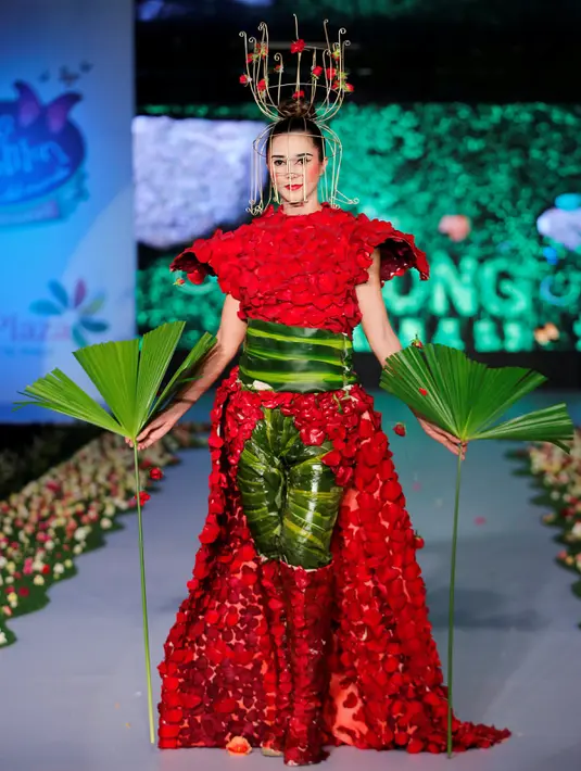 Seorang model berjalan diatas catwalk mengenakan busana yang terbuat dari aneka daun dan bunga yang dominan berwarna merah saat pergelaran Biofashion di Cali, Kolombia (19/11). (Reuters/Jaime Saldarriaga)