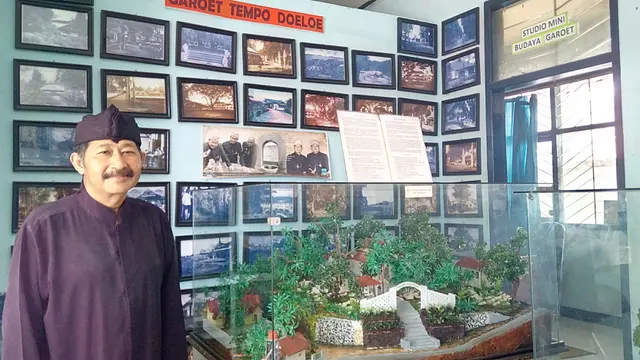 Asep Suryadi, Kepala Unit Pelaksana Teknis Museum RAA Adiwidjaja dan Bale Paminton Garut di depan deretan foto dalam ruangan museum