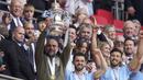 Pelatih Manchester City, Pep Guardiola (kiri) mengangkat trofi Piala FA setelah berhasil membawa Manchester City keluar sebagai juara dalam pertandingan final FA Cup 2022/2023 melawan Manchester United yang berlangsung di Wembley, Sabtu (3/6/2023) WIB. (AP Photo/Dave Thompson)