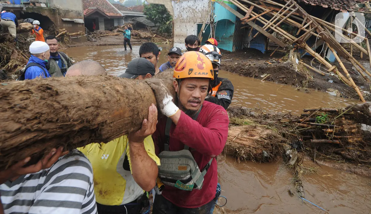 Tim SAR gabungan TNI, Polri, dan relawan membersihkan material longsor usai banjir bandang menerjang Kampung Cibuntu, Desa Pasawahan, Kecamatan Cicurug, Sukabumi, Selasa (22/9/2020). Banjir mengakibatkan puluhan bangunan rusak berat, 12 rumah hanyut, dan dua korban hilang. (merdeka.com/Arie Basuki)